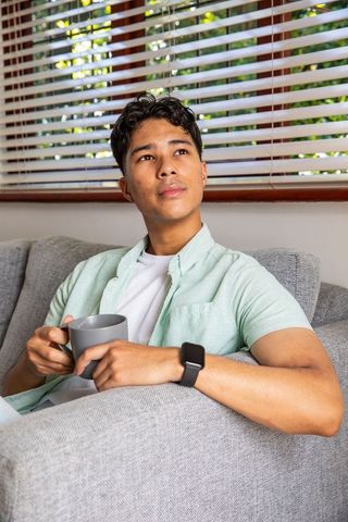 Young Man Relaxing with Mug Checking Smartwatch