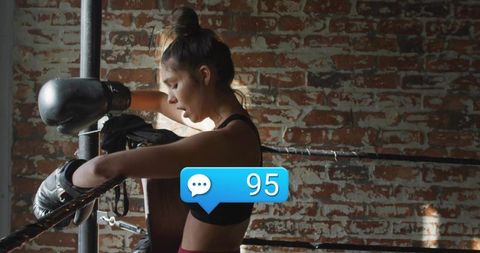 Female Boxer Resting in Ring with Social Media Engagement Notifications