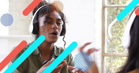 Woman wearing headphones talking and gesturing during collaborative podcast recording session