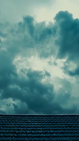 Vertical Video: Storm Clouds Closing Over Roof Tiles, Heavy Rain Approaching