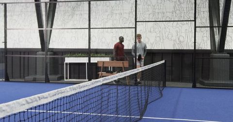 Diverse Male Friends Playing Paddle Tennis on Blue Turf Court