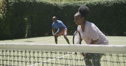 Happy Senior Couple Playing Tennis in Backyard Court