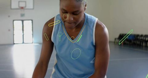 Focused basketball player practicing wearing gold pendant and neon graphic overlays