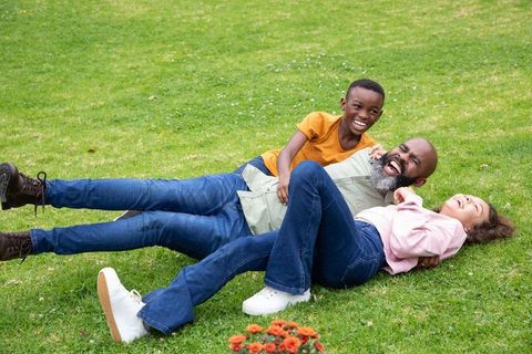 Happy Family Playtime on Lush Green Grass in Park
