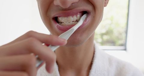 Asian Teen Brushing Teeth with Braces for Oral Hygiene