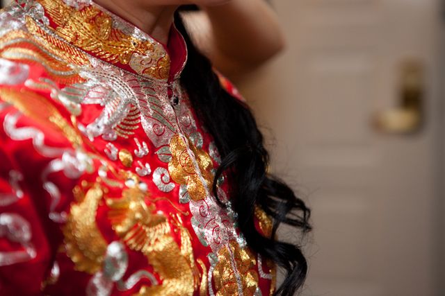 This image showcases a close-up of a traditional Chinese wedding dress adorned with gold and silver embroidery. The intricate design features floral and phoenix patterns, emphasizing cultural significance and craftsmanship. Ideal for use in wedding-related content, cultural articles, fashion blogs, and textile design inspirations.