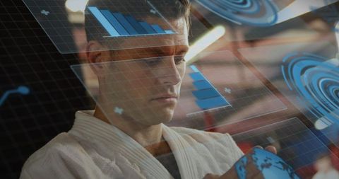 Man wearing white gi interacting with holographic globe and floating data charts