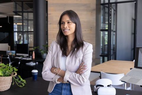 Young Asian professional woman leading modern office innovation with VR headset