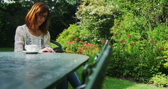 Woman Enjoying Coffee and Reading Outdoors in Beautiful Garden - Download Free Stock Images Pikwizard.com