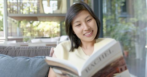 Woman relaxed reading book in cozy living room