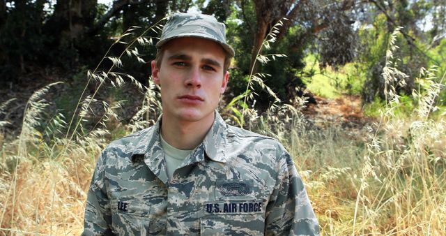 Depicting a US Air Force member standing outdoors in full uniform. This image can be used for articles about military life, recruitment campaigns, journals celebrating Veterans, or promoting outdoor activities and adventures for service members.