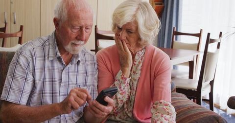 Elderly couple calculating finances at home during pandemic