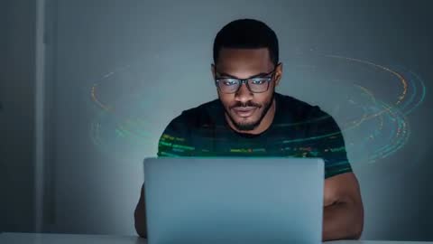 Black man analyzing holographic data on laptop while futuristic rings orbit workspace