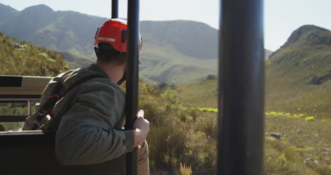 Adventurous Man Enjoying Mountain View on Sunny Journey