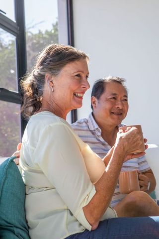 Senior Couple Enjoying Coffee in Sunny Living Room