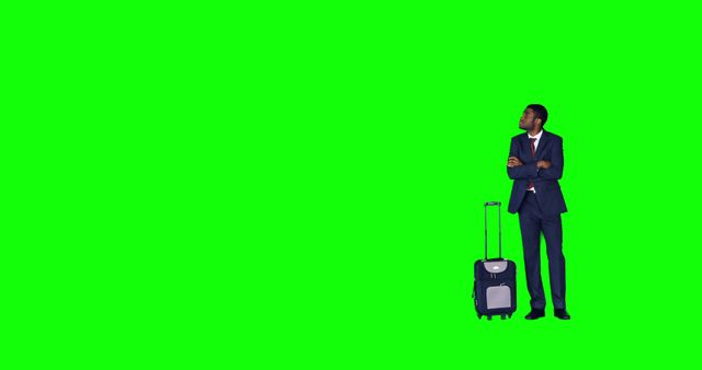 Businessman in suit standing with crossed arms next to wheeled luggage, facing to the right. Green screen background allows for customization and versatile use in different contexts. Suitable for travel, business promotions, or advertisement design.