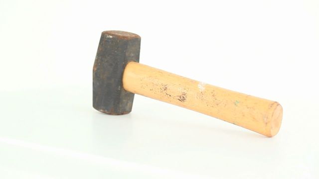 Old and used hammer rotating against white backdrop. Ideal for concepts related to construction, carpentry, DIY projects, and craftsmanship. Perfect for blogs, advertisements, and educational materials related to tools and home improvement.