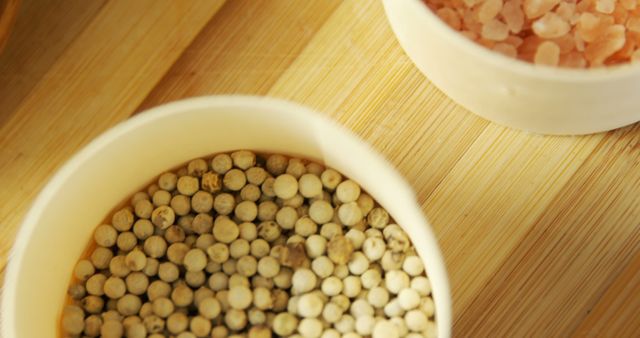 White Peppercorns and Pink Himalayan Salt in Ceramic Bowls on Bamboo Surface - Download Free Stock Images Pikwizard.com