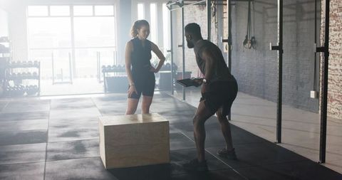 Personal trainer guiding workout in modern gym