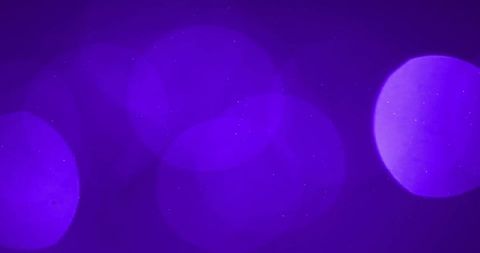 Abstract glowing light spots on purple background