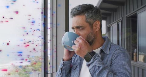 Man Relaxing with Coffee on Coastal Balcony with Ocean View
