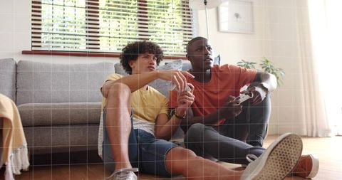 Two friends playing video games on living room floor, casual multiplayer gaming session