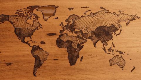 Engraved world map on wooden panel highlighting natural grain