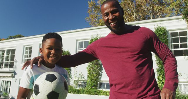 Portrait of african american dad and son smiling while holding a football in the garden - Download Free Stock Photos Pikwizard.com