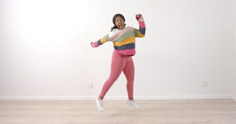 Joyful African American Woman Dancing in Colorful Attire