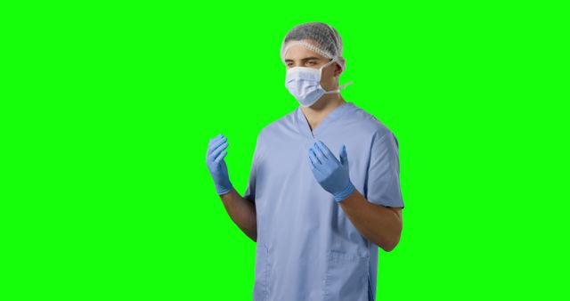 Young Caucasian male nurse stands ready in scrubs on a green screen, with copy space. His professional attire suggests a healthcare setting, prepared for medical tasks.