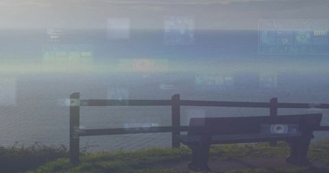 Solitary bench overlooking misty ocean with digital HUD overlays and coastal railing
