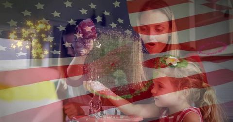 Mother and daughters sprinkling glitter while baking in patriotic kitchen, us flag overlay