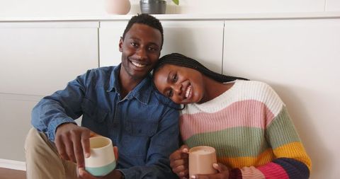 Comfortable Couple Relaxing at Home with Warm Drinks and Smiles
