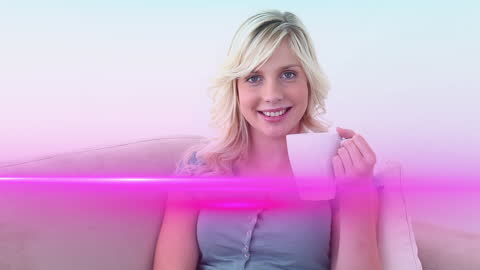 Smiling Woman Relaxing with Coffee on Sofa Enhanced with Pink Flare