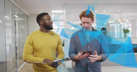 Collaborating colleagues studying digital data overlays on tablet and clipboard in modern office