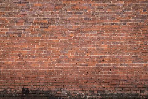 Plain aged red brick wall background with weathered texture