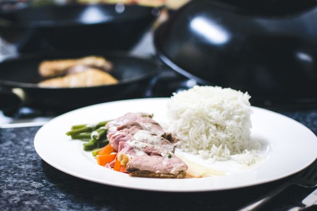 This close-up showcases a well-prepared plate of steak, green beans, and steamed white rice, making it perfect for culinary blogs, restaurant advertisements, or cooking guides. Its appealing arrangement and vibrant colors make it ideal for promoting balanced diets and home-cooked meals.