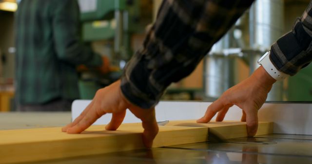 Woodworker's hands preparing wood plank for cutting on table saw in workshop - Download Free Stock Images Pikwizard.com