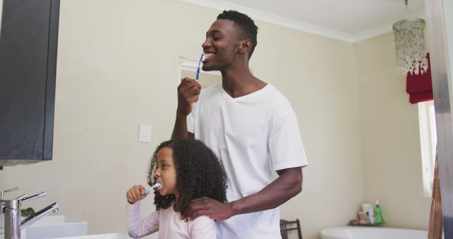 Father brushing teeth with daughter in bathroom mirror, daily oral hygiene routine - Download Free Stock Images Pikwizard.com