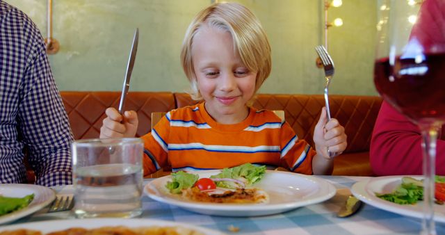 Happy Boy Enjoying Meal in Family Restaurant - Download Free Stock Images Pikwizard.com