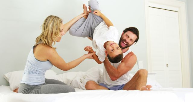 Happy Parents Playing With Their Son On Bed During Morning - Download Free Stock Images Pikwizard.com