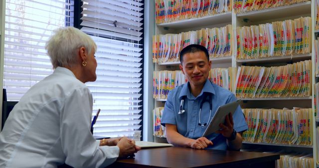 Doctor consulting elderly patient using tablet in office - Download Free Stock Images Pikwizard.com