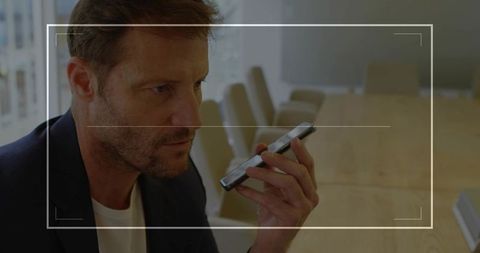 Businessman Using Smartphone Voice Command in Modern Office