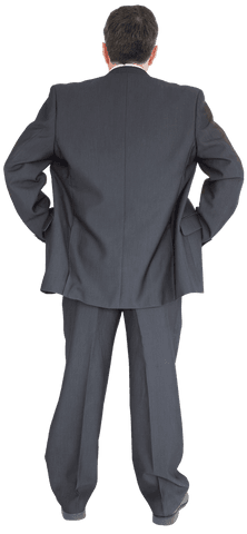 Businessman standing back to camera in suit, hands on hips being transparent