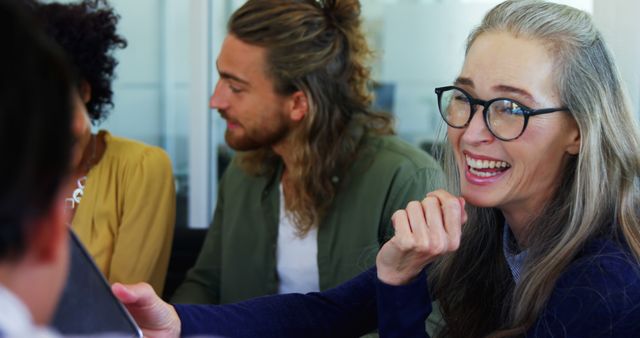 Diverse coworkers laughing and collaborating during office meeting - Download Free Stock Images Pikwizard.com