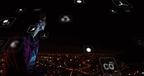 Woman gazing over city at night with holographic tech icons, futuristic rooftop view
