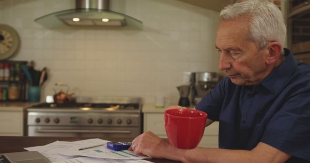 Senior Man Reviewing Financial Documents in Kitchen - Download Free Stock Images Pikwizard.com