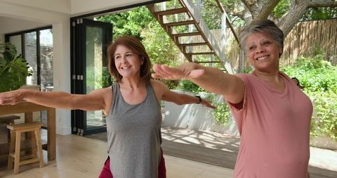 Women practicing warrior ii yoga pose in well-being environment