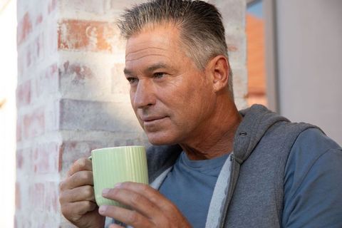 Middle-aged Man Enjoying Coffee on Cozy Front Porch