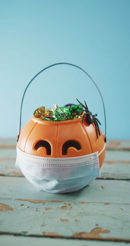 Halloween pumpkin basket with mask full of candy